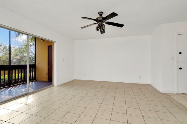 empty room with ceiling fan and light tile patterned floors