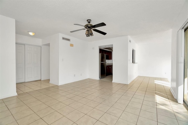 tiled spare room with ceiling fan and a textured ceiling