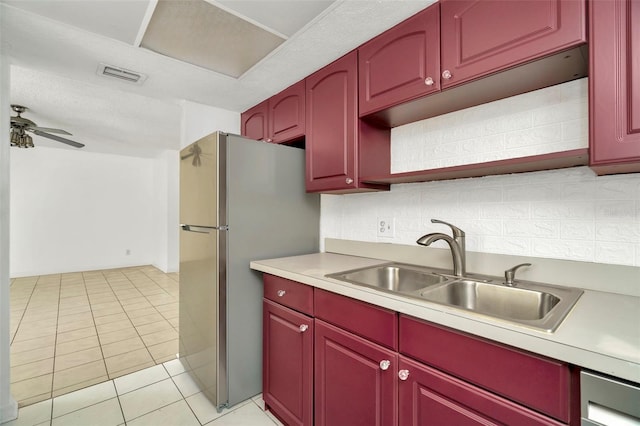 kitchen with sink, light tile patterned floors, stainless steel fridge, ceiling fan, and backsplash