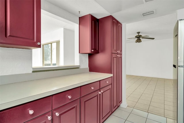 kitchen with tasteful backsplash, ceiling fan, light tile patterned floors, and stainless steel refrigerator