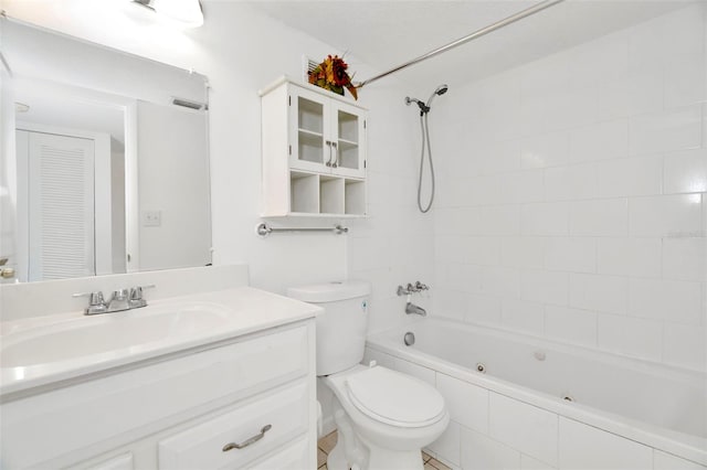 full bathroom with tiled shower / bath, vanity, and toilet