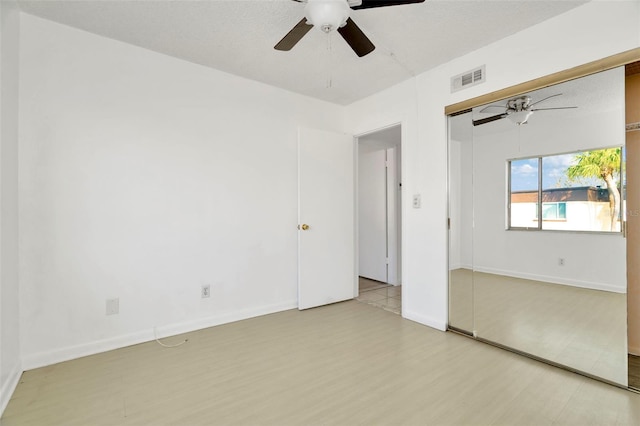 empty room with ceiling fan and light hardwood / wood-style flooring