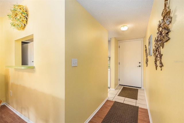 hallway featuring a textured ceiling and light wood-type flooring