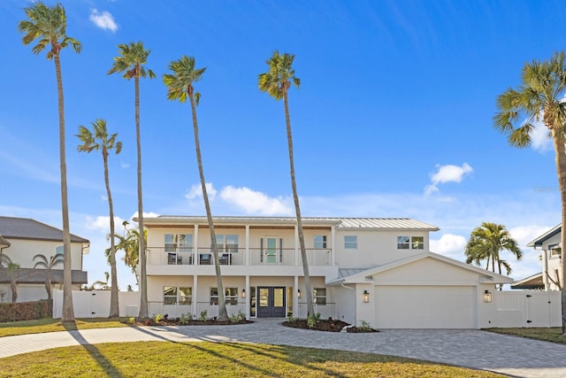 view of front facade featuring a balcony, a garage, and a front lawn