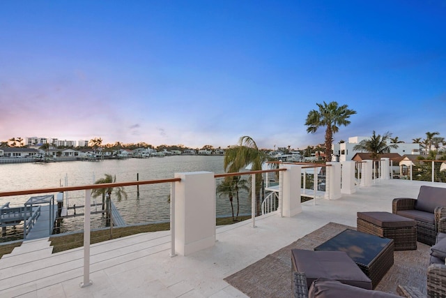 patio terrace at dusk featuring an outdoor living space and a water view