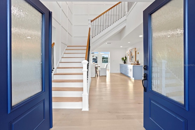 foyer with light hardwood / wood-style flooring and a high ceiling