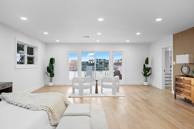 bedroom with a water view and light hardwood / wood-style flooring