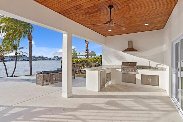 view of patio / terrace featuring a water view, area for grilling, ceiling fan, and an outdoor bar