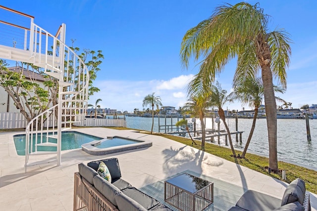 view of pool with a patio, outdoor lounge area, a water view, and an in ground hot tub