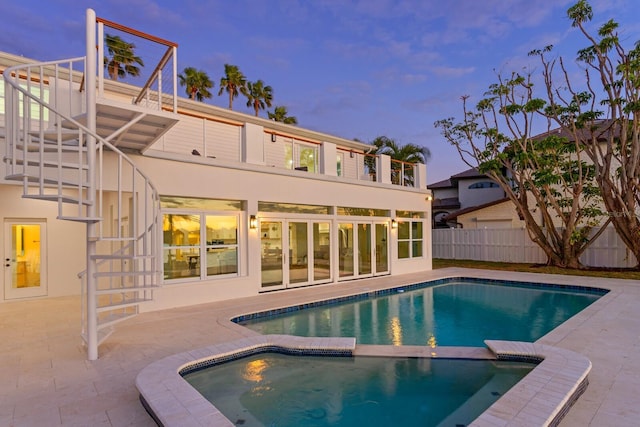 pool at dusk featuring a patio area