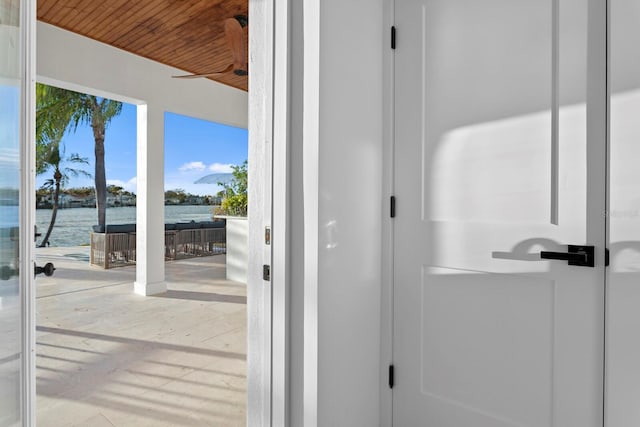 doorway to outside featuring wood ceiling, ceiling fan, and a water view