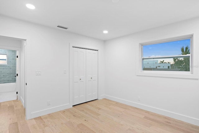 unfurnished bedroom featuring a closet and light wood-type flooring