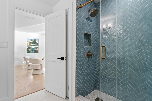 bathroom with a shower with shower door and tile patterned flooring