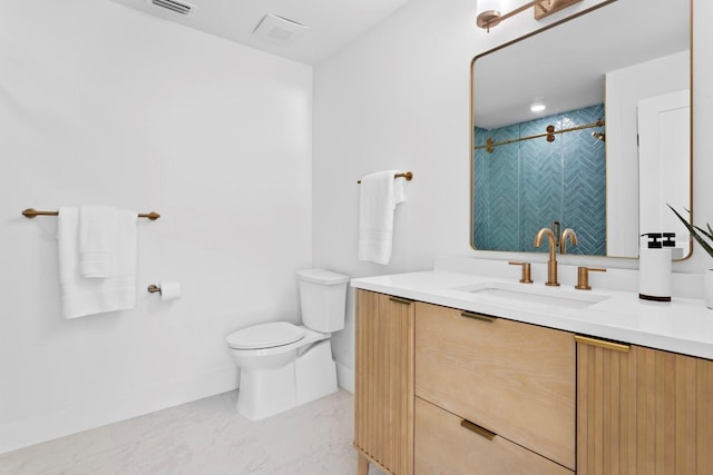 bathroom with tiled shower, vanity, and toilet