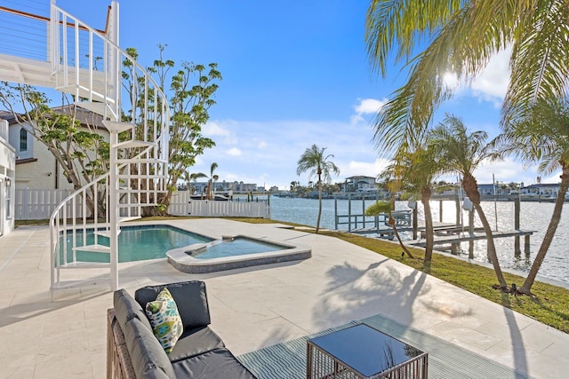 view of pool with an in ground hot tub, a water view, and a patio area