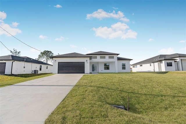 view of front of property featuring cooling unit, a garage, and a front lawn