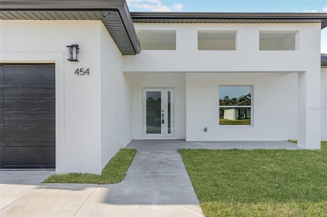 entrance to property featuring a lawn