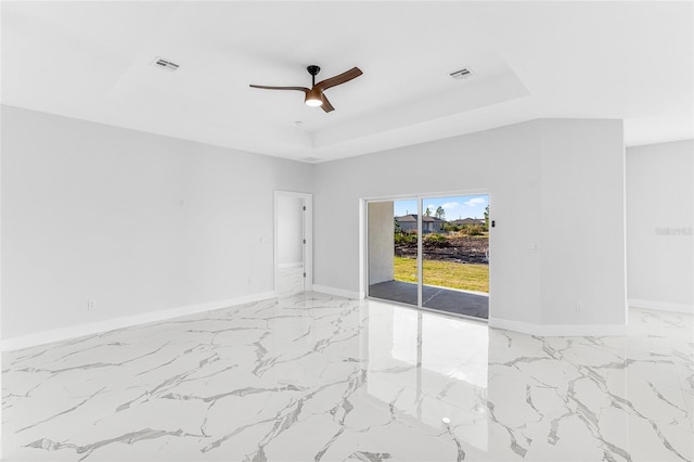 spare room featuring ceiling fan and a tray ceiling