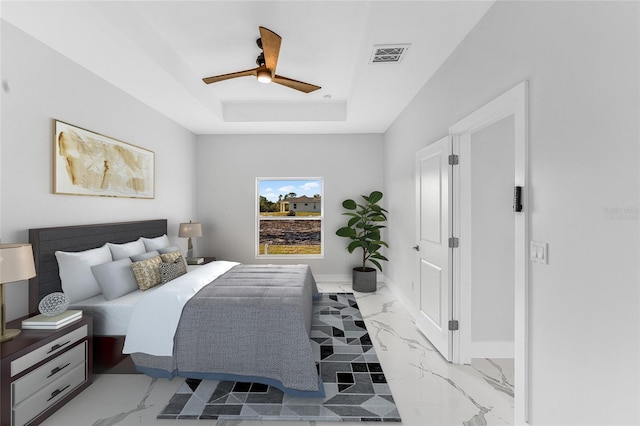 bedroom featuring ceiling fan and a tray ceiling