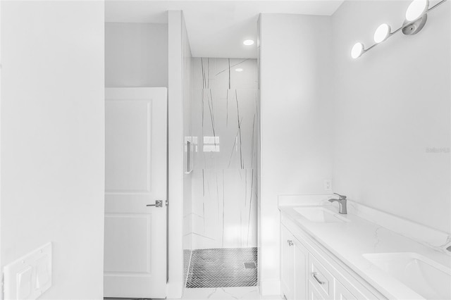 bathroom with tiled shower and vanity