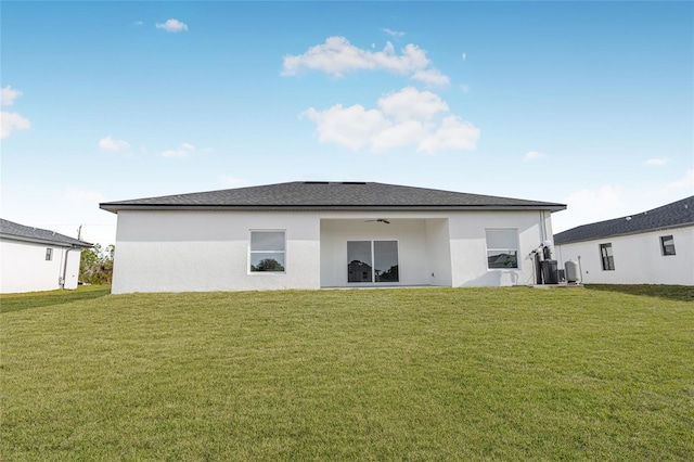 rear view of property with a yard and ceiling fan