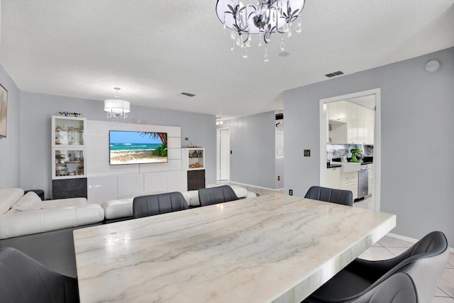 dining space featuring a textured ceiling and a notable chandelier