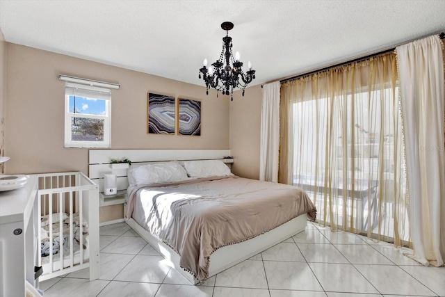 bedroom featuring an inviting chandelier, light tile patterned floors, and a textured ceiling