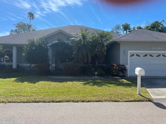 single story home with a garage and a front lawn