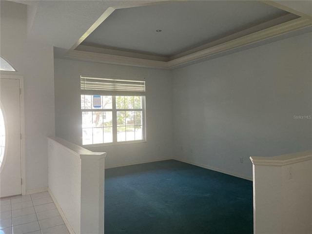 tiled empty room with a tray ceiling