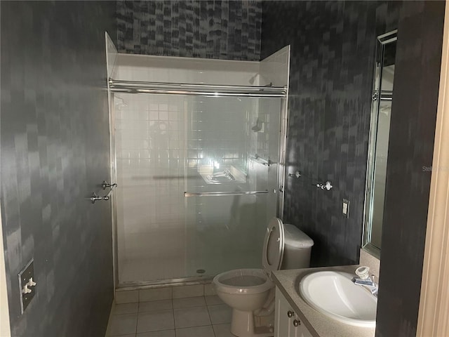 bathroom with tile patterned floors, toilet, an enclosed shower, and vanity