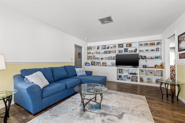 living room featuring dark wood-type flooring and built in features