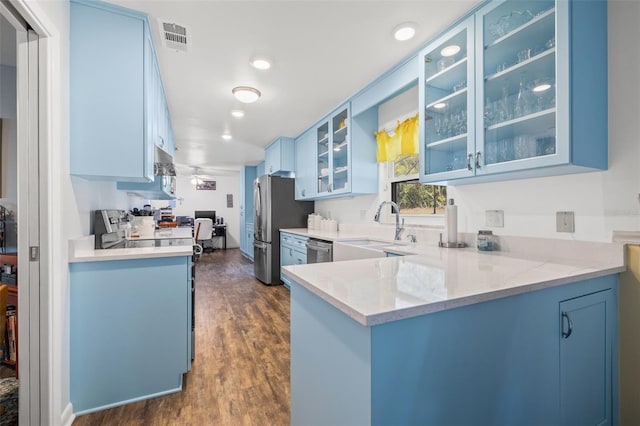 kitchen with blue cabinets, sink, kitchen peninsula, stainless steel appliances, and light stone countertops