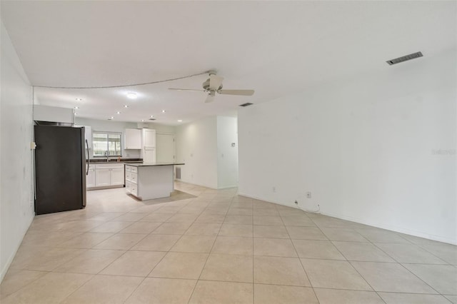 unfurnished living room with light tile patterned floors and ceiling fan