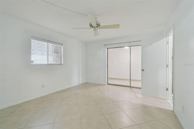 tiled empty room featuring ceiling fan