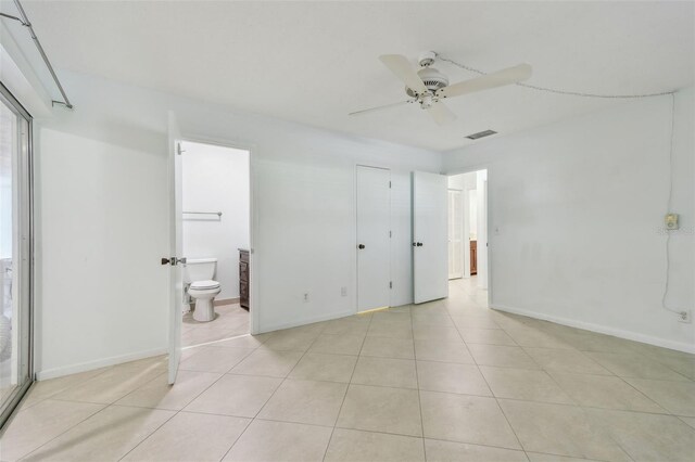 unfurnished bedroom with light tile patterned floors, ceiling fan, and ensuite bathroom