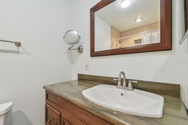 bathroom with vanity, walk in shower, and toilet