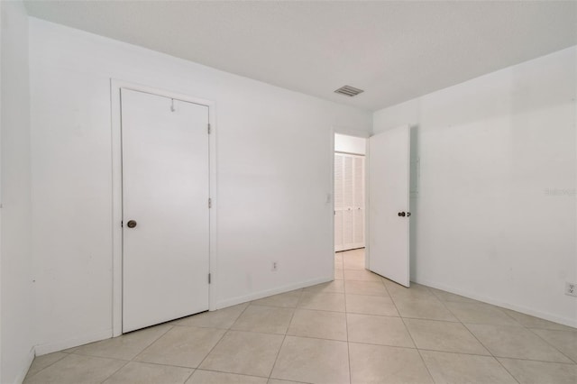 unfurnished bedroom with a textured ceiling and light tile patterned floors