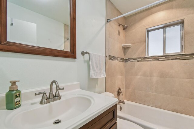 full bathroom with vanity, tiled shower / bath combo, and toilet