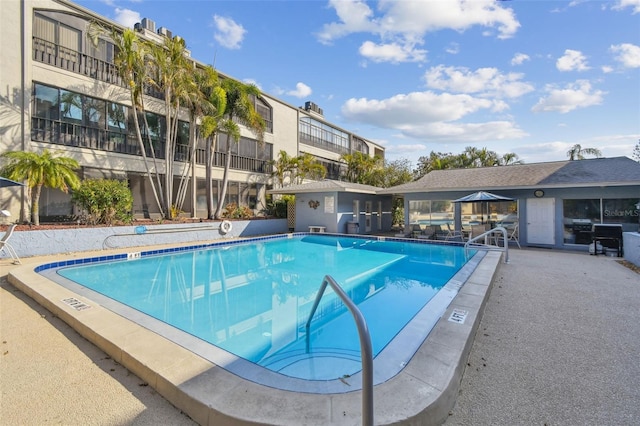 view of swimming pool featuring area for grilling and a patio