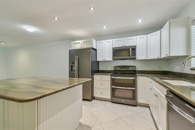 kitchen with sink, white cabinetry, stainless steel appliances, and light tile patterned floors