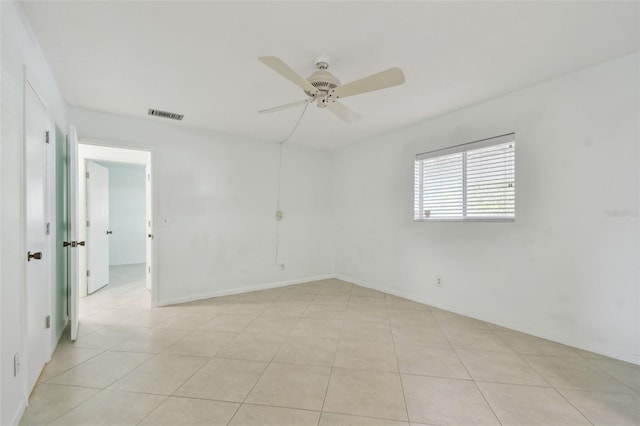 tiled spare room with ceiling fan