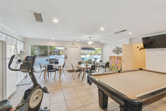 rec room with a textured ceiling, billiards, and light tile patterned floors