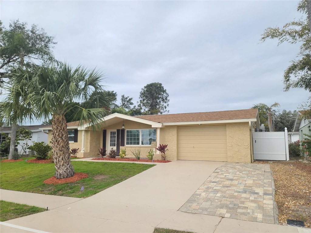 ranch-style house with a garage and a front lawn