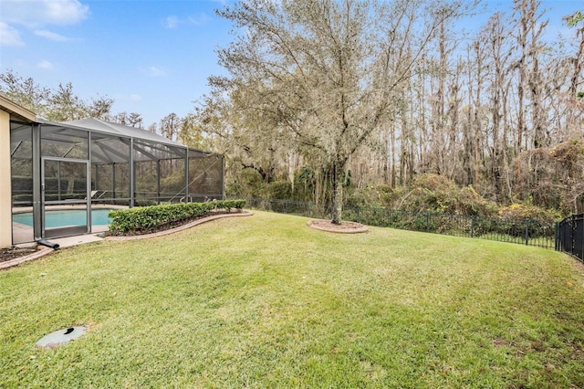 view of yard featuring glass enclosure, a fenced backyard, and a fenced in pool