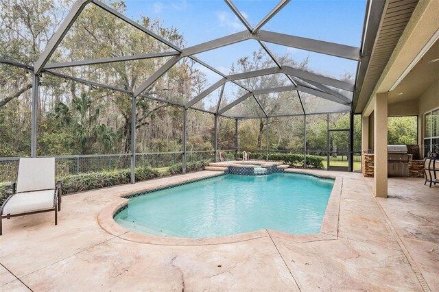 view of swimming pool featuring a pool with connected hot tub, a patio area, area for grilling, and a lanai