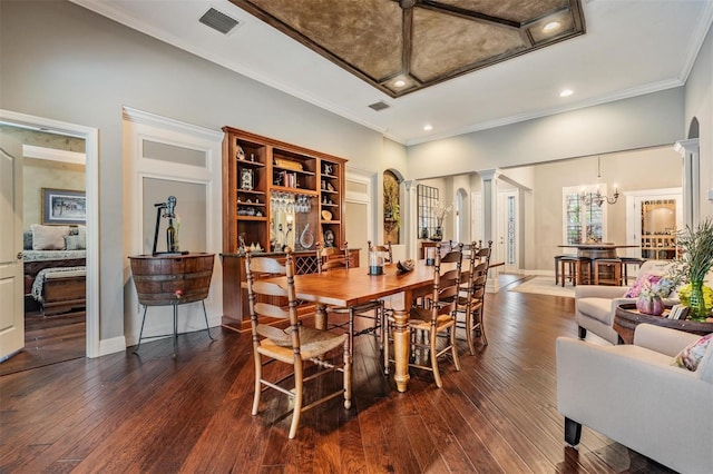 dining room featuring decorative columns, visible vents, ornamental molding, baseboards, and hardwood / wood-style flooring