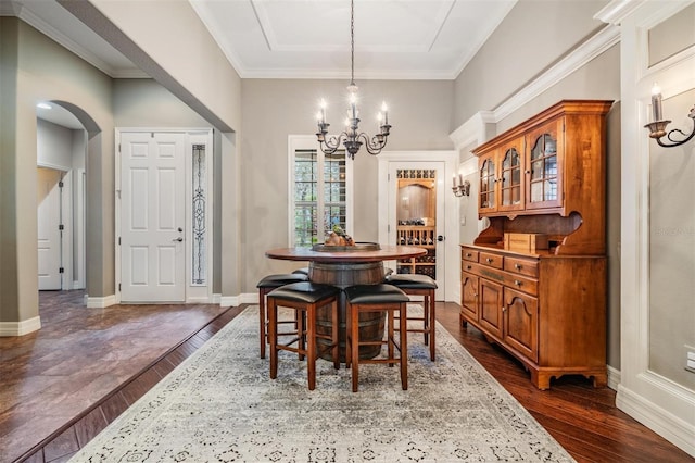 dining space with arched walkways, a chandelier, dark wood-style flooring, baseboards, and ornamental molding