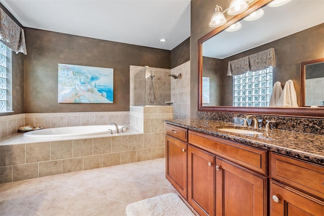 bathroom with a garden tub, vanity, a walk in shower, and tile patterned floors