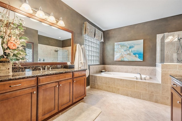 bathroom featuring tile patterned flooring, a tile shower, vanity, and a bath