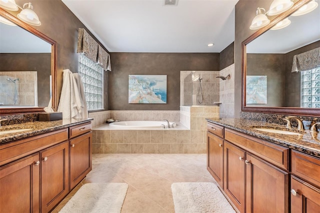 bathroom with two vanities, a sink, a bath, and a walk in shower